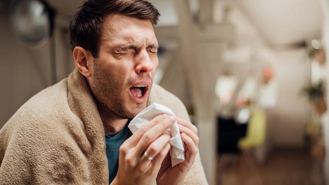 Sick young man coughing and sneezing. Picture: Supplied