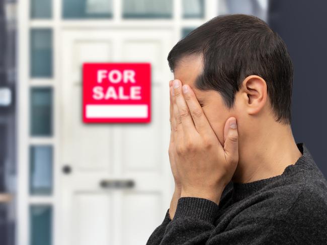 Man extremely depressed and sad about losing his house key and seeing a for sale sign, real estate concept; first home buyer generic sad, stressed