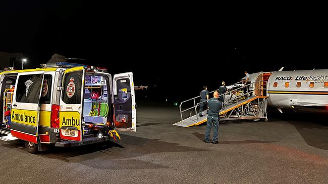 Paramedics meet a LifeFlight jet in Brisbane after a mass casualty event on Norfolk Island. Picture: LifeFlight