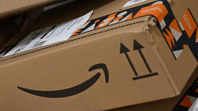 Packages with the logo of Amazon are transported at a packing station of a redistribution centre of US online retail giant Amazon in Horn-Bad Meinberg, western Germany, on December 9, 2024. (Photo by Ina FASSBENDER / AFP)