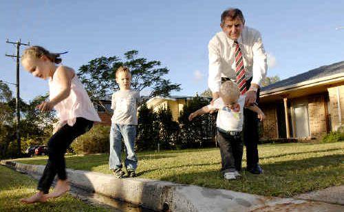 Health concerns: Water with high levels of faecal coliforms and hatching mosquito larvae lies stagnant in a stormwater drain at Evans Head. Jon Lawrence wants something done to fix the problem so his grandchildren (from left) Sophie, 6, William, 4, and Jacob Laing, 20 months, can play safely in his yard. Picture: David Nielsen