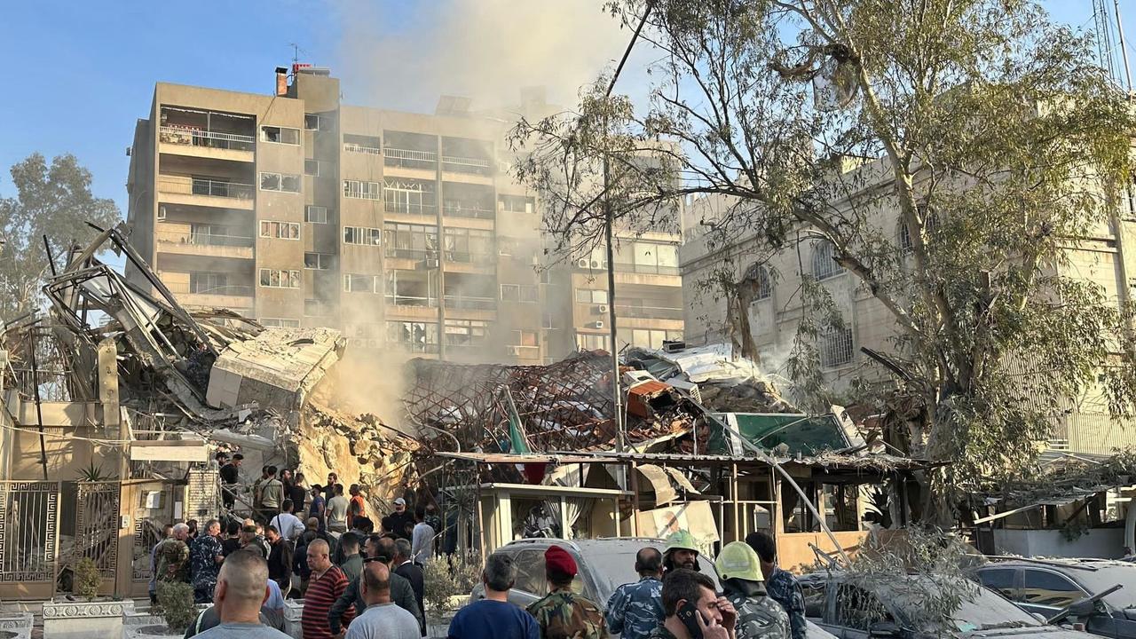 Emergency and security personnel gather at the site of strikes which hit a building adjacent to the Iranian embassy in Syria's capital Damascus, on April 1, 2024. Israeli strikes hit Syria's capital on April 1, state media reported, as a war monitor said six people were killed in a building adjacent to the Iranian embassy. (Photo by Maher AL MOUNES / AFP)