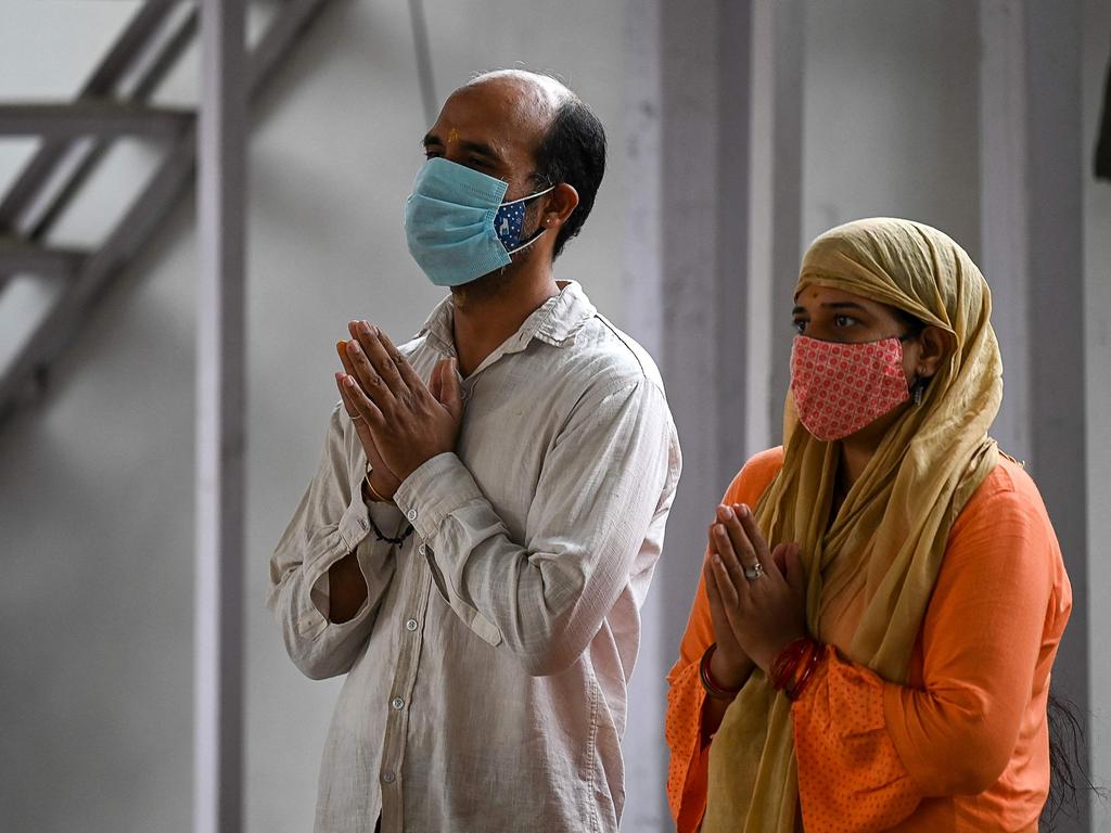 A couple offer prayers outside the closed Jhandewalan Goddess temple in New Delhi. Picture: AFP