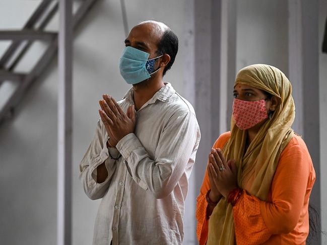 A couple offer prayers outside the closed Jhandewalan Goddess temple in New Delhi. Picture: AFP