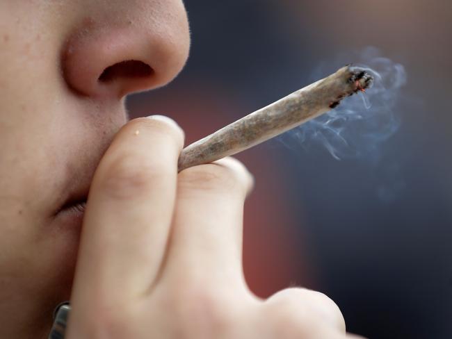 (FILES) In this file photo taken on May 12, 2018 a man smokes a joint during a demonstration for the decriminalization of cannabis in France, in Paris. - Starting from November 19, 2018 French deputies will examine the new draft-law concerning the justice reform. Among the points raised : the creation of a fixed fine of 200 euros in case of cannabis use. (Photo by Thomas SAMSON / AFP)