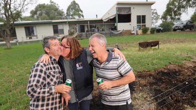 While Susie Edwards was away in Perth her neighbours Rick Hodge (left) and Greg Brick (right) saved her house from the flames at the base of the property in Buchan. Picture: Alex Coppel.