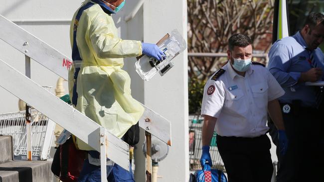 Paramedics leave the unit block at Cooks Hill where Wes Prentice was killed. Picture: Peter Lorimer