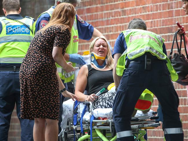 A woman cries in pain as she is taken away by ambulance. Picture: Ian Currie