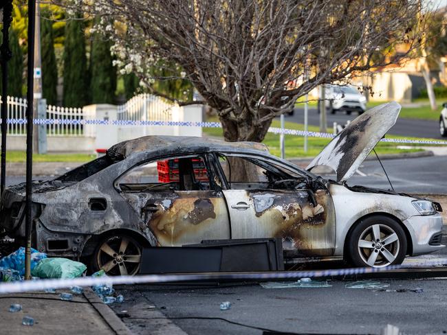 The charred remains of the car backed up outside the store. Picture: Jason Edwards