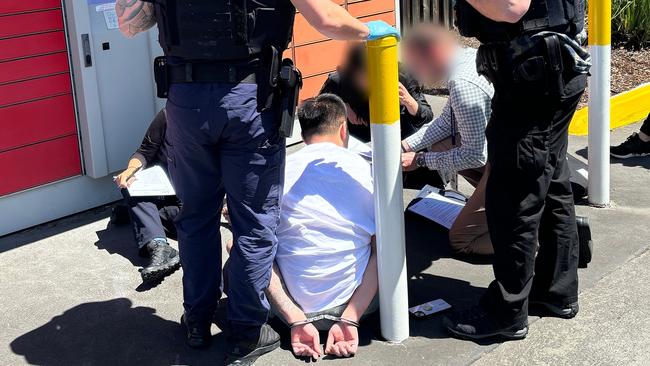 Police detain a Chinese national at a Burwood service station after he allegedly tried to collect some of the pseudoephedrine from a parcel locker. Picture: ABF