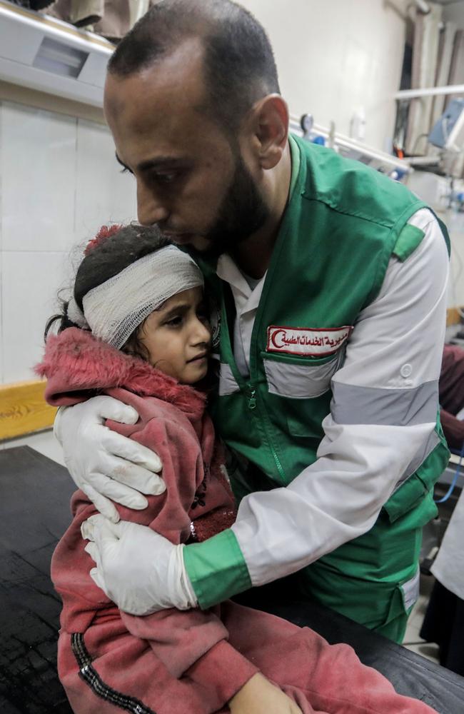 A man consoles a young girl as Palestinians injured in air strikes arrive at Nasser Medical Hospital in Khan Yunis, Gaza. Picture: Getty Images