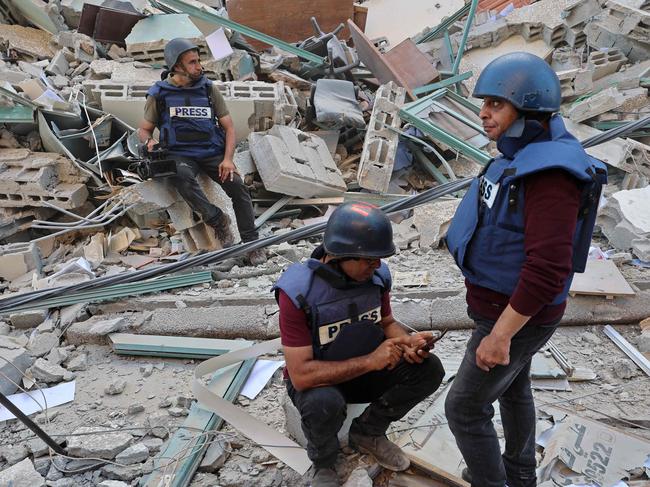 Journalists sit in the rubble of Jala Tower, which was housing international press offices, following an Israeli air strike in the Gaza Strip. Picture: AFP