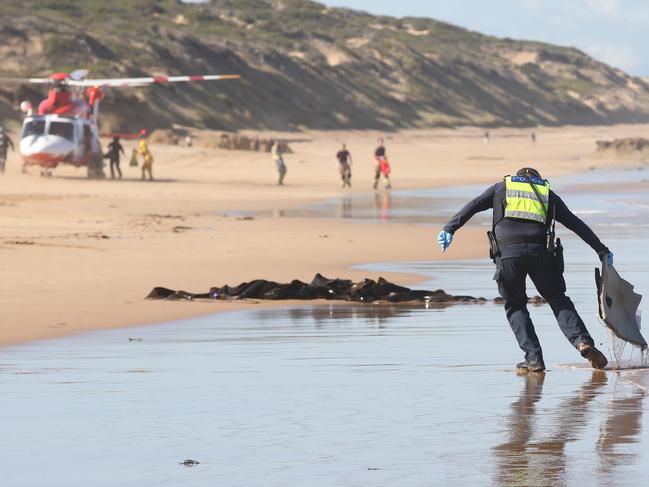 Police removed debris from the wreckage before the tide came in. Picture: Alan Barber