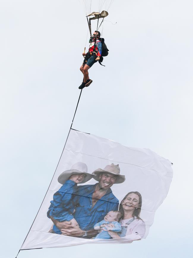 Skydivers bring down a giant flag bearing the family at the funeral for local Civil Engineer and TV Star Chris ‘Willow’ Wilson at the Darwin Convention centre. Picture: Glenn Campbell