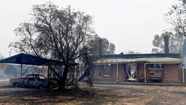 The remains of a car and a house that fell victim to the Angle Vale fire. Picture: Naomi Jellicoe