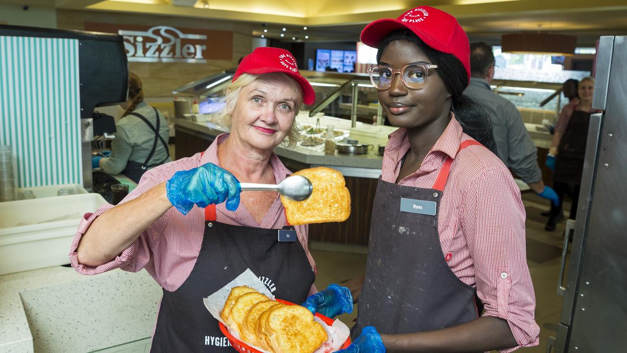 Staff members Niki Ryan (left) and Abul Deng serve Sizzlers iconic cheesy toast on the last day of trading before Sizzler restaurants close, Sunday, November 15, 2020. Picture: Kevin Farmer