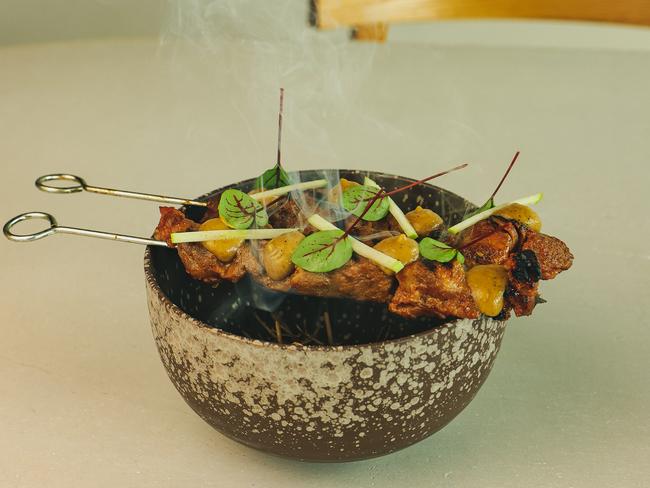 Sizzling pork skewers add some tableside theatrics. Picture: Lachlan Phyland