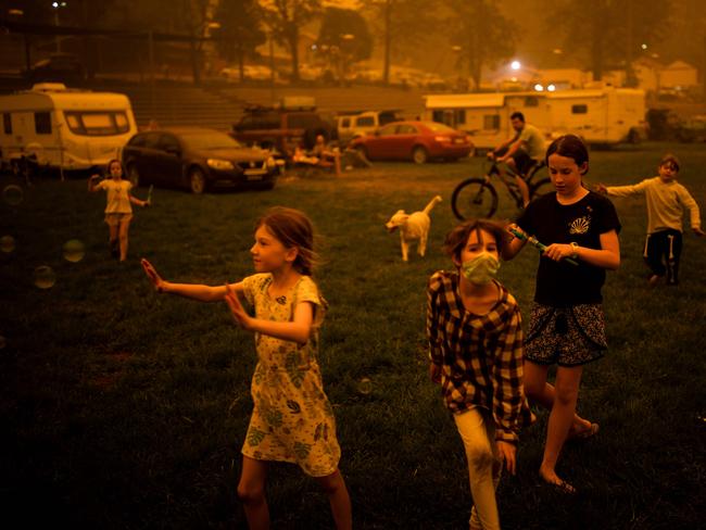 Children play at the showgrounds in the southern New South Wales town of Bega where they are camping after being evacuated from nearby sites affected by bushfires on December 31, 2019. - Thousands of holidaymakers and locals were forced to flee to beaches in fire-ravaged southeast Australia on December 31, as blazes ripped through popular tourist areas leaving no escape by land. Picture: Sean Davey/AFP