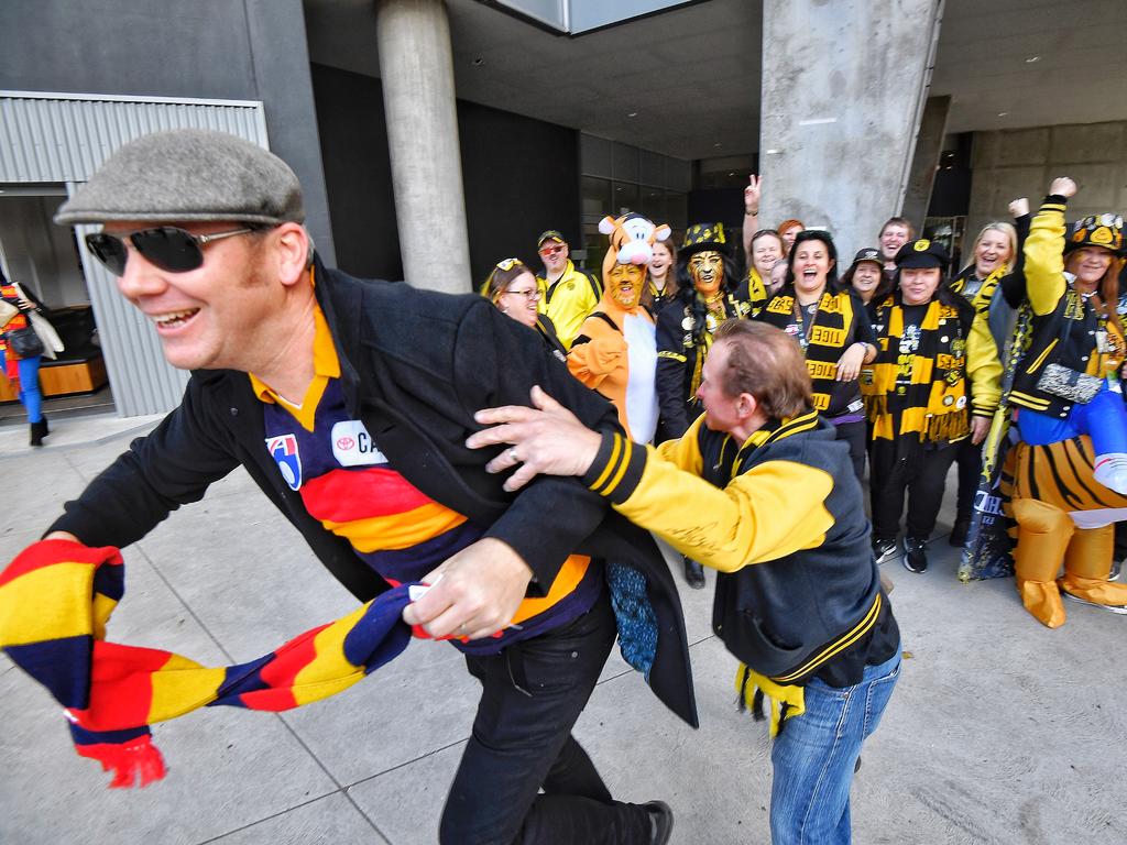 A Crows fan crashes a Tigers supporters’ photo. Picture: Jason Edwards