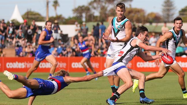 Zak Butters gets a kick away despite pressure from Bailey Smith. Picture: Matt Turner/AFL Photos via Getty Images.