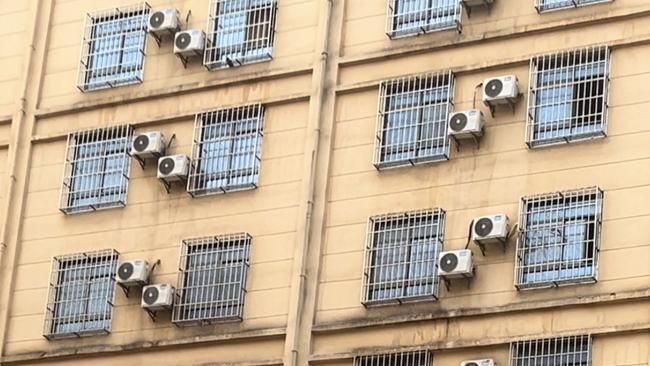 The back and front side of one of the scam compounds in Golden Triangle SEZ where workers can be seen at night pressed up against the window bars of their rooms. Picture: Amanda Hodge