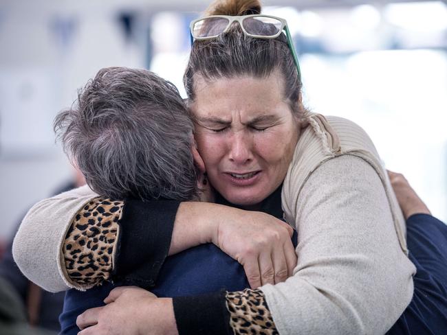 Mourners comfort each other at a community gathering in Cowes. Picture: Jake Nowakowski