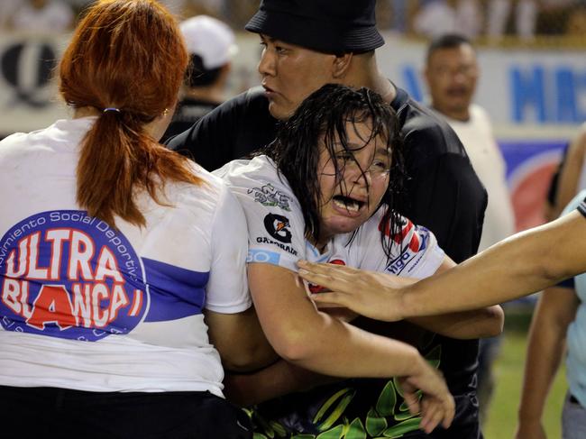 A woman is held by other as she cries following a stampede during a football match between Alianza and FAS at Cuscatlan stadium in San Salvador, on May 20, 2023. Nine people were killed May 20, 2023 in a stampede at an El Salvador stadium where soccer fans had gathered to watch a local tournament, police said. (Photo by Milton FLORES / AFP)