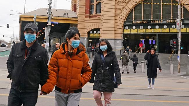 People leave a subdued Flinders Street Station as Melbourne goes into its second lockdown Picture: AAP