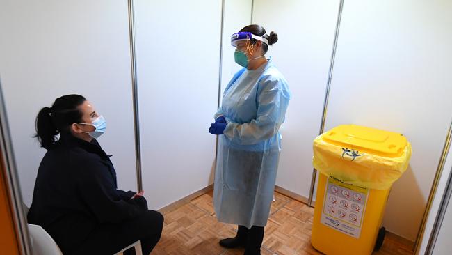 A health care worker speaks to a staff member in the COVID-19 staff testing area at the Grand Hyatt Melbourne in Melbourne.