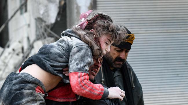 EDITORS NOTE: Graphic content / TOPSHOT - Residents carry an injured child from the rubble of a collapsed building following an earthquake in the town of Jandaris, in the countryside of Syria's northwestern city of Afrin in the rebel-held part of Aleppo province, on February 6, 2023. - Hundreds have been reportedly killed in north Syria after a 7.8-magnitude earthquake that originated in Turkey and was felt across neighbouring countries. (Photo by Rami al SAYED / AFP)