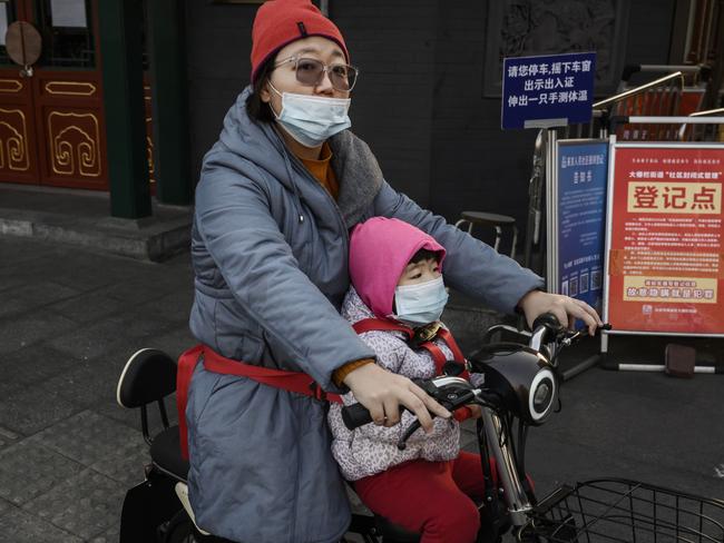 BEIJING, CHINA - MARCH 11: A Chinese woman and her daughter wear protective masks as they ride on a scooter on March 11, 2020 in Beijing, China. The number of cases of the deadly new coronavirus COVID-19 being treated in China dropped to below 16,500 in mainland China Wednesday, in what the World Health Organization (WHO) declared a global public health emergency last month. China continued to lock down the city of Wuhan, the epicentre of the virus, in an effort to contain the spread of the pneumonia-like disease but has moved to ease restrictions in other parts of the province. Officials in Beijing have put in place a mandatory 14 day quarantine for all people returning to the capital from other places in China and abroad. The number of those who have died from the virus in China climbed to over 3160 on Wednesday, mostly in Hubei province, and cases have been reported in many other countries including the United States, Canada, Australia, Japan, South Korea, India, Iran, Italy, the United Kingdom, Germany, France and several others. The World Health Organization has warned all governments to be on alert and raised concerns over a possible pandemic. Some countries, including the United States, have put restrictions on Chinese travellers entering and advised their citizens against travel to China.(Photo by Kevin Frayer/Getty Images)