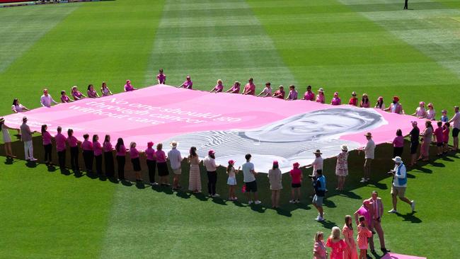 Volunteers unveil a huge banner in front of the members stand at the start of day 3 of the 5th Test. Picture: Tom Parrish