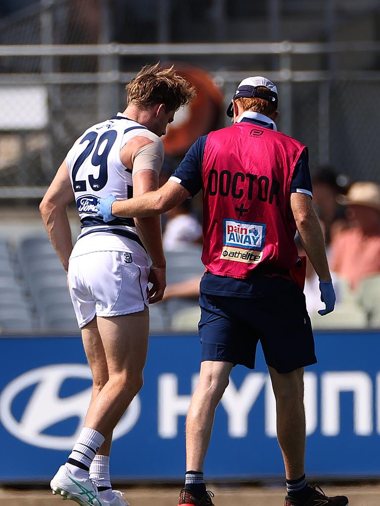 Cam Guthrie leaves the field after injuring himself in the opening 30 seconds of Geelong’s first competitive hitout against opposition. Picture: Kelly Defina/Getty Images.