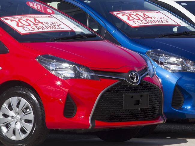 Cover shoot for CarsGuide ...new year sales Nunawading Toyota sales man, Miles Towner places stickers on 2014 plate cars in preparedness for 2014 plate sale. Picture: Sarah Matray