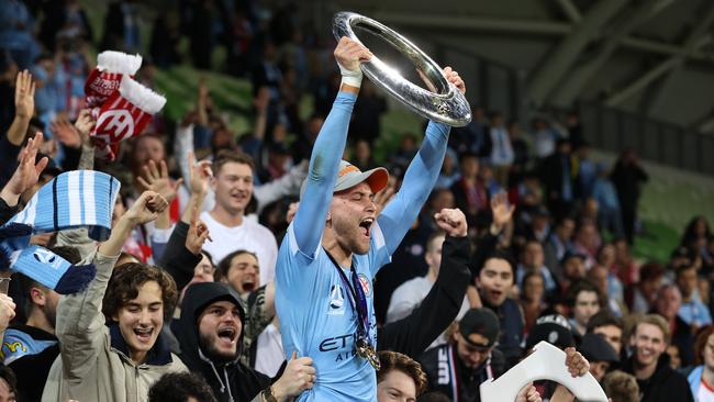 Nathaniel Atkinson of Melbourne City celebrates victory with fans and holds aloft the A-League trophy after winning the A-League Grand Final match between Melbourne City and Sydney FC at AAMI Park, on June 27, 2021 in Melbourne, Australia. (Photo by Robert Cianflone/Getty Images)