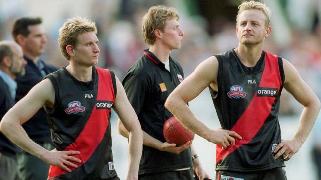 James Hird and John Barnes watch Brisbane players receive their 2001 premiership medals.