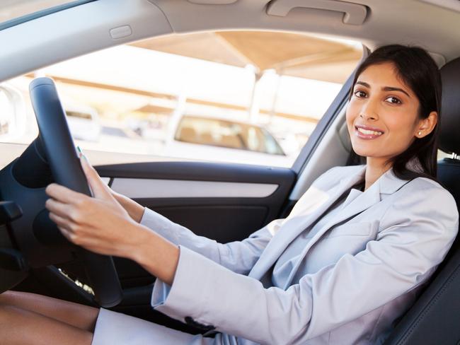 A woman dressed in a suit driving her car to work. Picture: iStock.