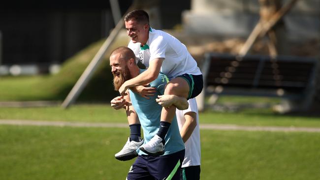 Andrew Redmayne gives his Socceroos teammate Cameron Devlin a piggy-back during a training session in Doha last month. Picture: Getty Images