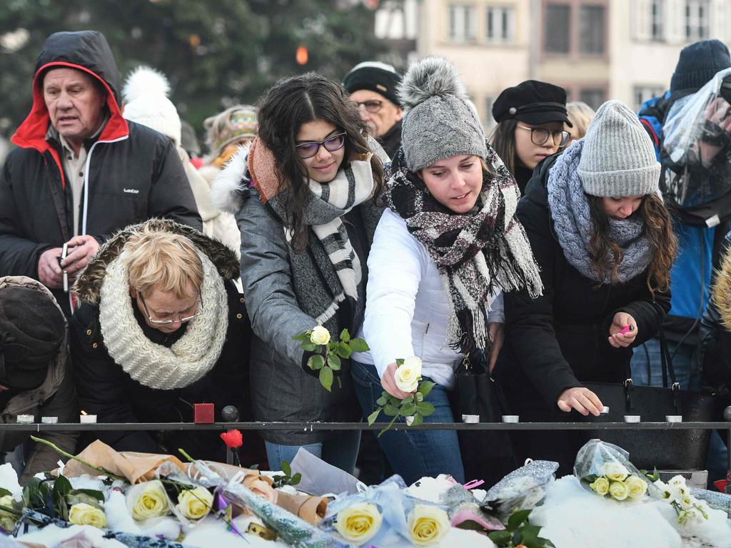 People light candles and leave flowers during a gathering around a makeshift memorial at Place Kleber, in Strasbourg. Picture: AFP