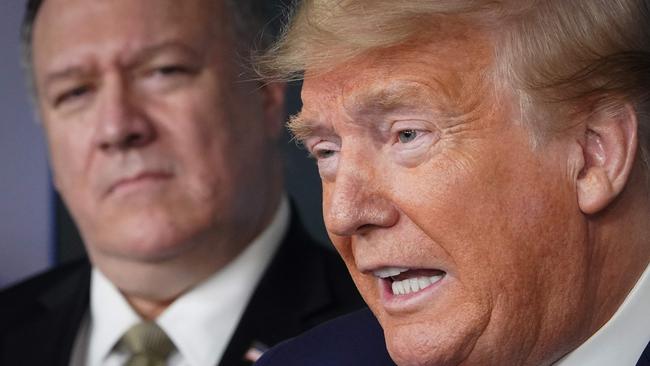 Former secretary of state Mike Pompeo, left, listens to Donald Trump during a White House briefing in April 2020. Mr Pompeo is in the running to be secretary of defence in the president-elect’s new administration. Picture: AFP