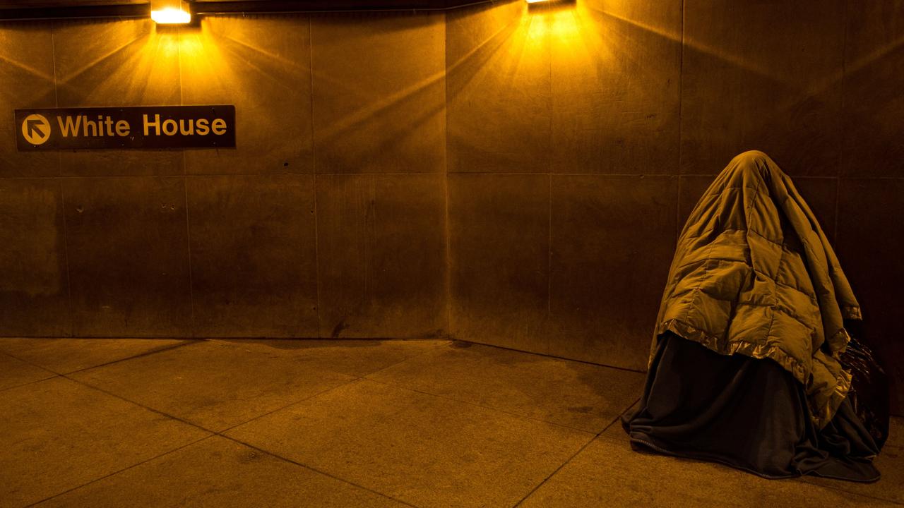 A homeless person covered in blankets for warmth sleeps at the entrance of a Metro station near the White House in Washington, DC. Picture: AFP