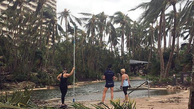 Residents remove fallen trees and branches from the roads on Hamilton Island. Picture: Dennis Garrett