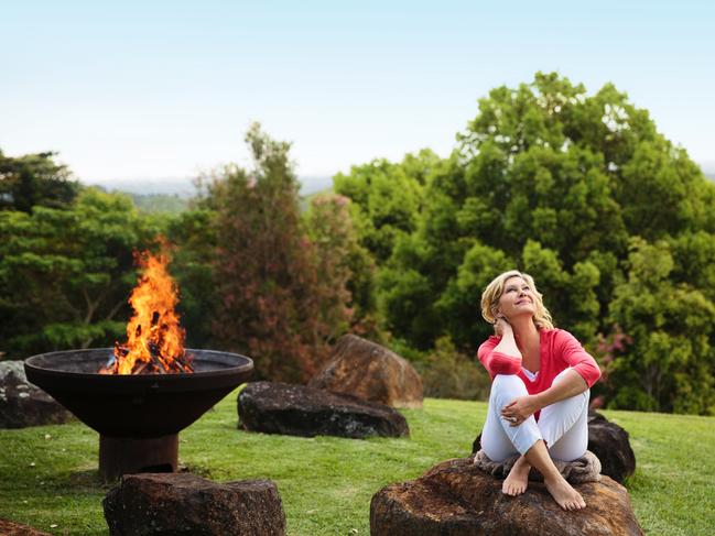 Olivia Newton-John at Gaia Retreat relaxing by the fire. Picture: Kate Nutt