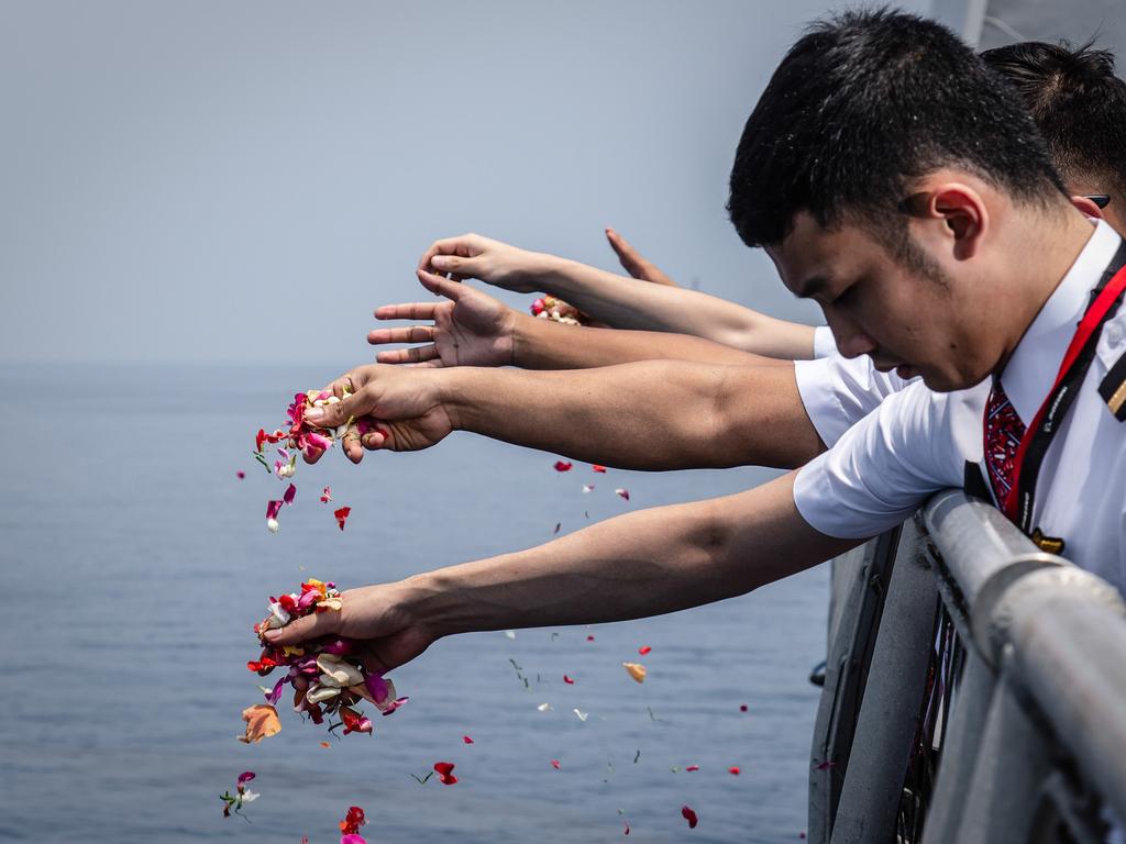 Colleagues of victims of Lion Air flight JT 610 throw flowers on deck of Indonesian Navy ship KRI Banjarmasin. Picture: Getty