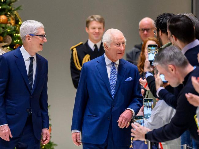 Britain's King Charles III (C) with Chief Executive of Apple, Tim Cook (L), visits the firmâs UK headquarters, in London, on December 12, 2024. (Photo by Paul Grover / POOL / AFP)