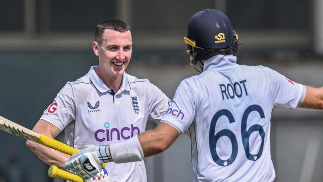 England's Harry Brook (L) celebrates with teammate Joe Root after scoring a double century (200 runs) during the fourth day of the first Test cricket match between Pakistan and England at the Multan Cricket Stadium in Multan on October 10, 2024. (Photo by Aamir QURESHI / AFP)