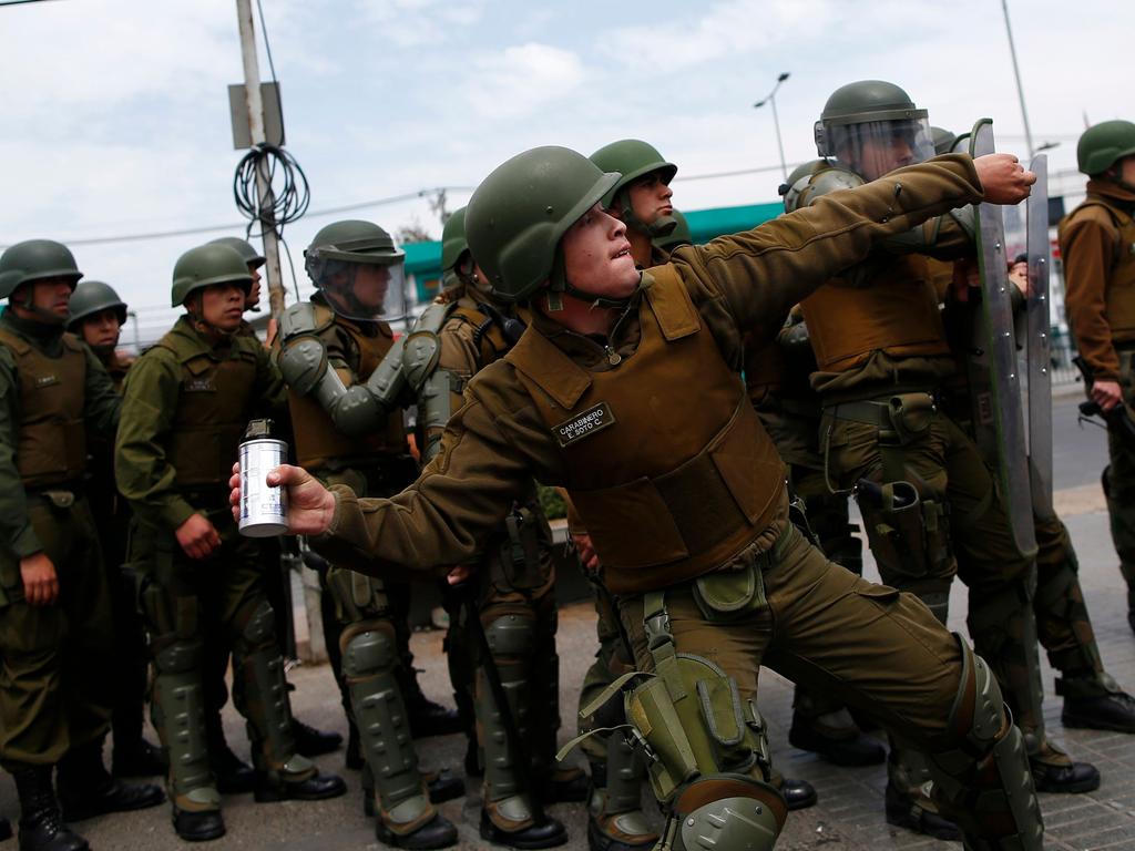 A police throws a tear gas can during clashes with protesters. Picture: AFP