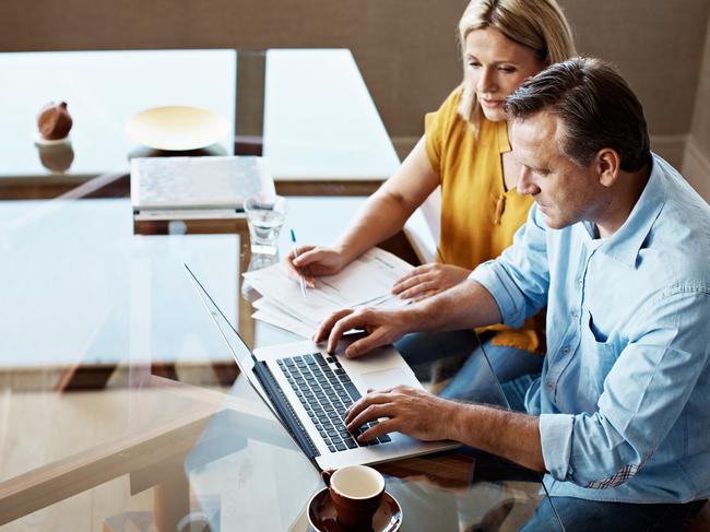 Shot of a mature couple paying their bills online from home