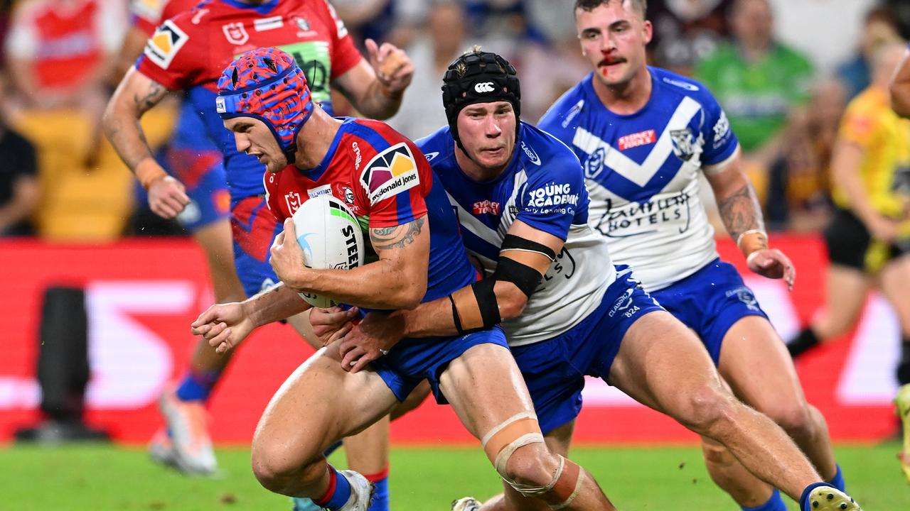 Kalyn Ponga can’t slip past Matt Burton. Picture: Bradley Kanaris/Getty Images