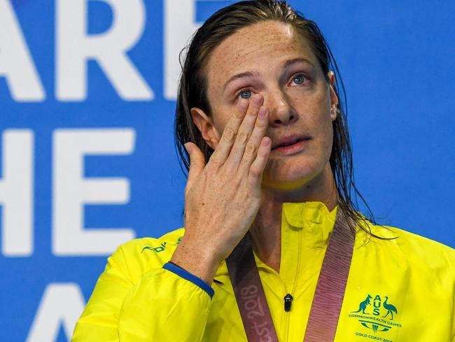 Australia 's Cate Campbell (gold) cries as she pose with her medal after the swimming women's 50m freestyle final during the 2018 Gold Coast Commonwealth Games at the Optus Aquatic Centre in the Gold Coast on April 7, 2018 / AFP PHOTO / Anthony WALLACE